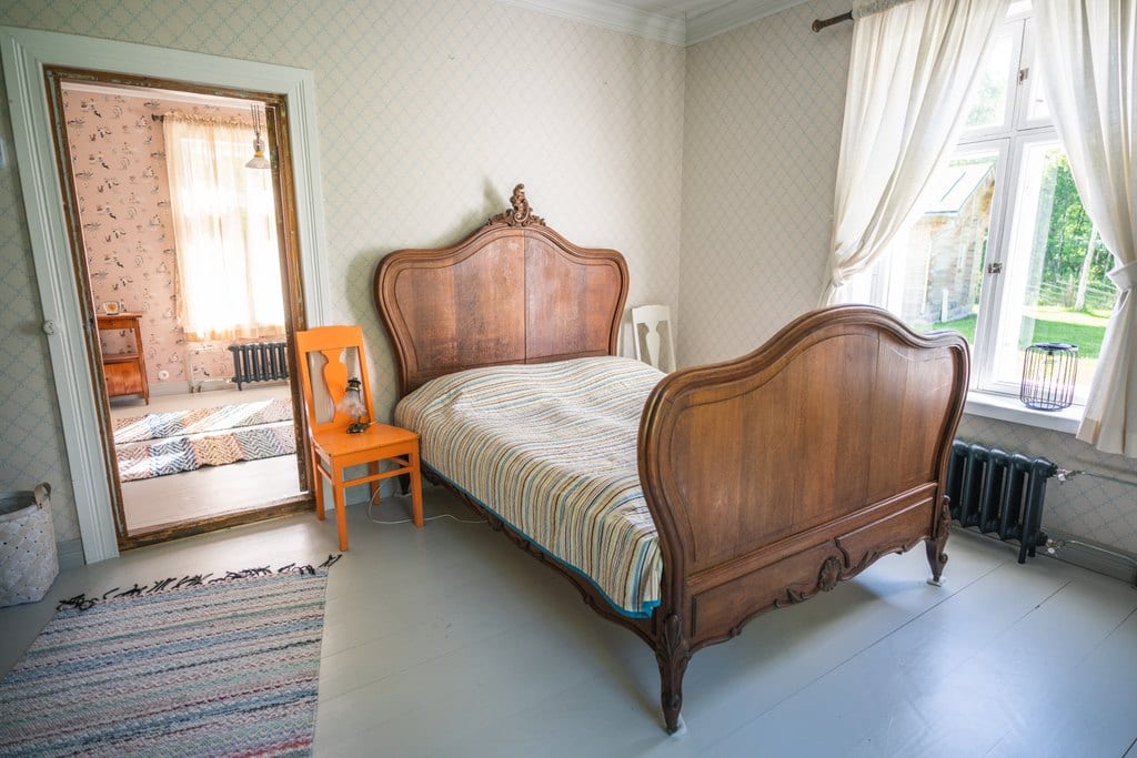 Pauhu bedroom with a wooden double bed and orange chair