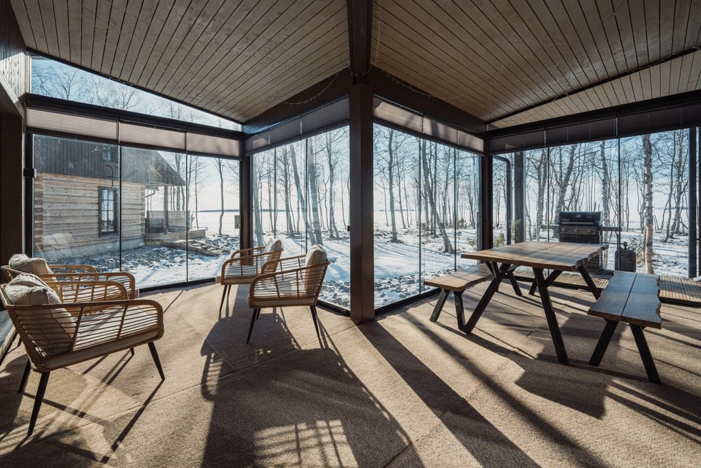 Glazed terrace with chairs, a table and a grill in winter