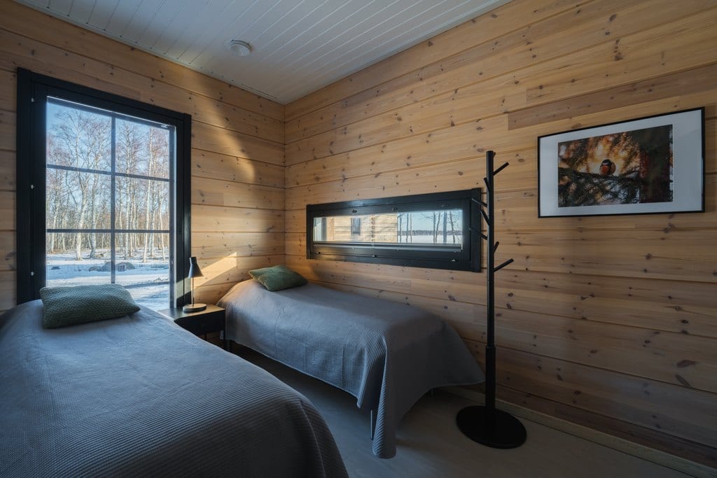 Bedroom with two single beds and log walls