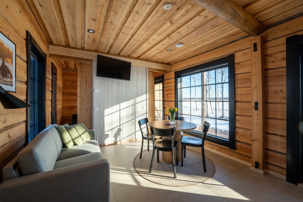Log cabin living room with sofa and round dining table