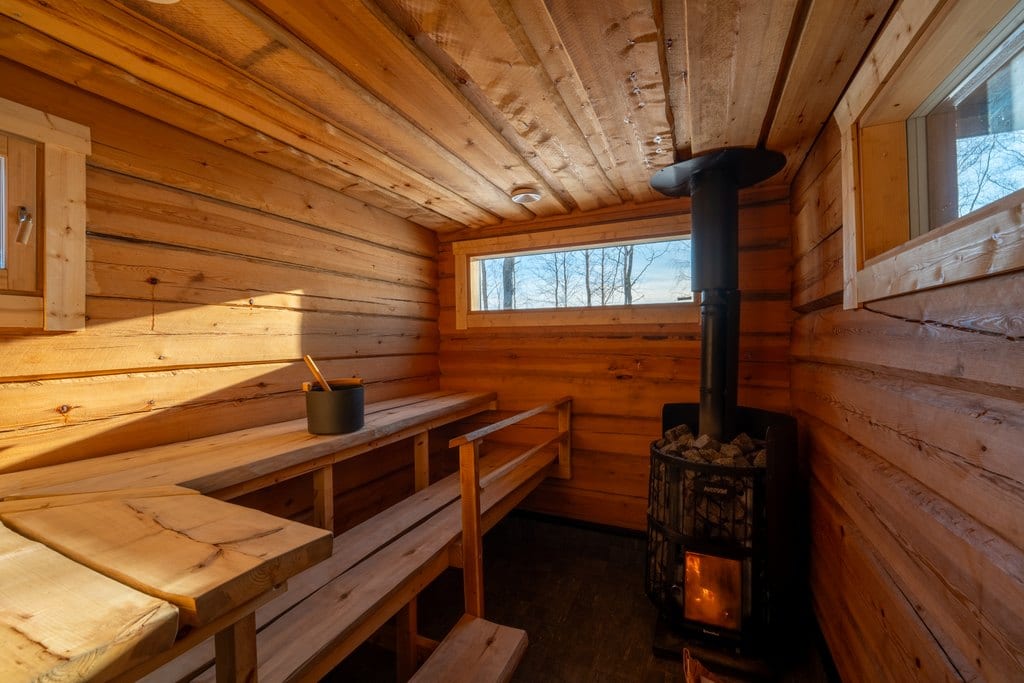 Log sauna with a wood-burning stove and benches