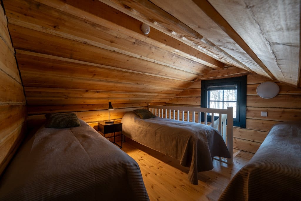 Log loft sleeping area with three beds
