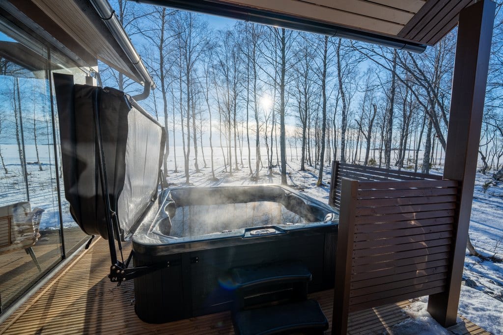 Steaming hot tub on a covered terrace in winter