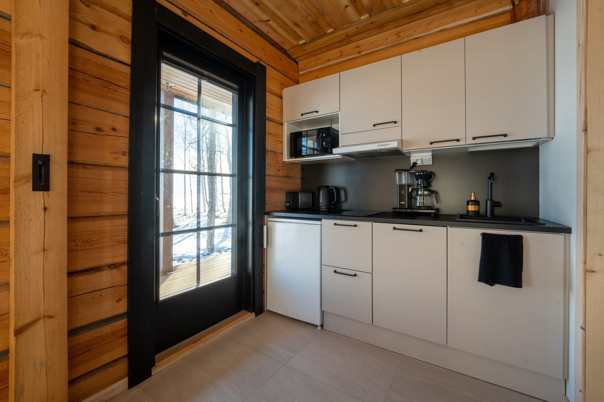 Uitto kitchen with a glass door to the snowy deck