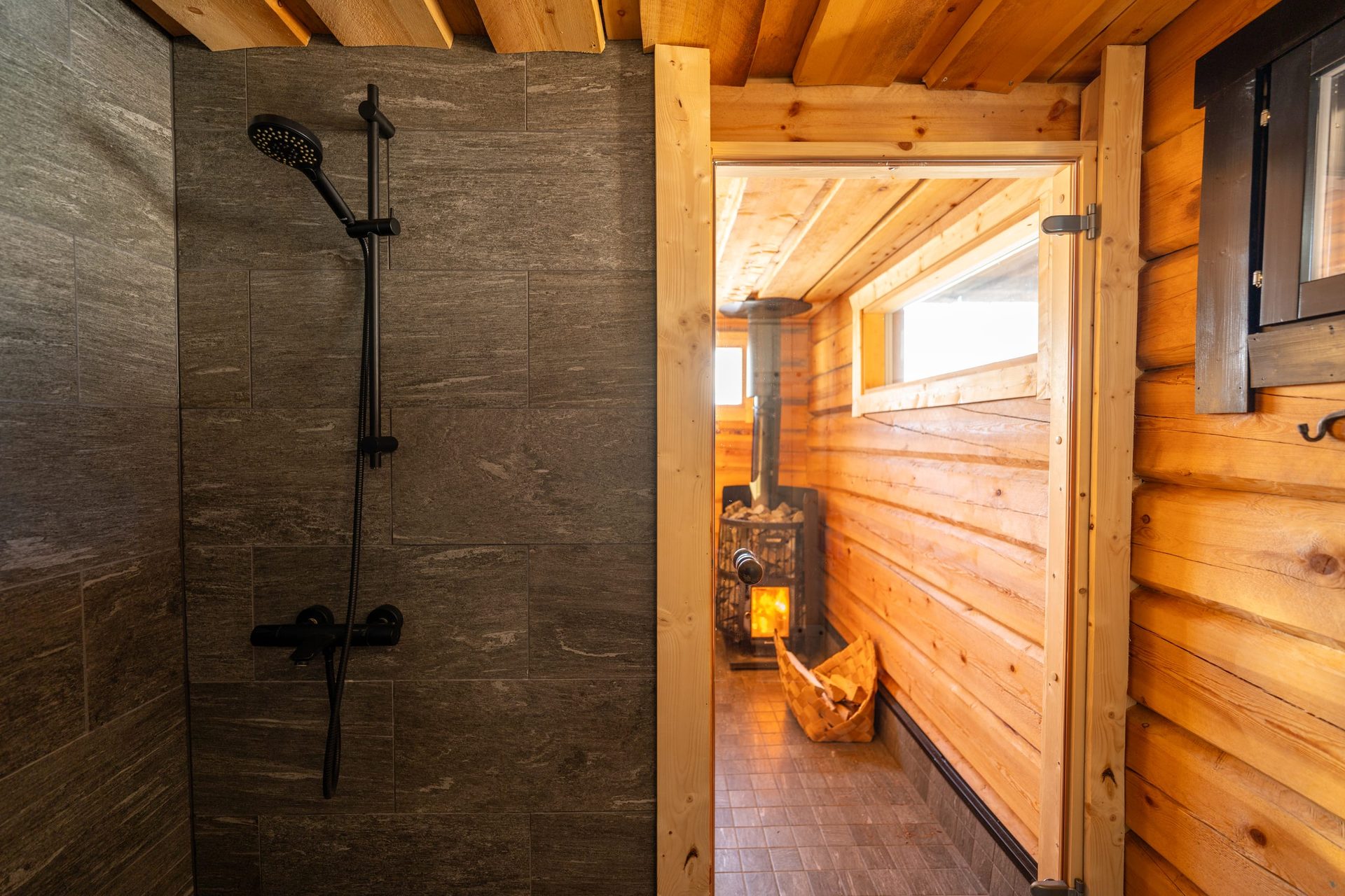 Usva shower with a view into the sauna and lit stove