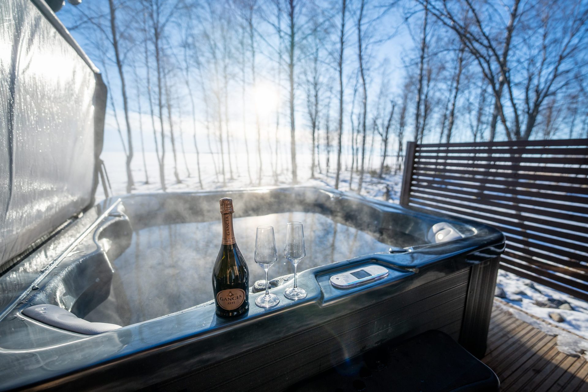 Usva hot tub with sparkling wine and two glasses in winter