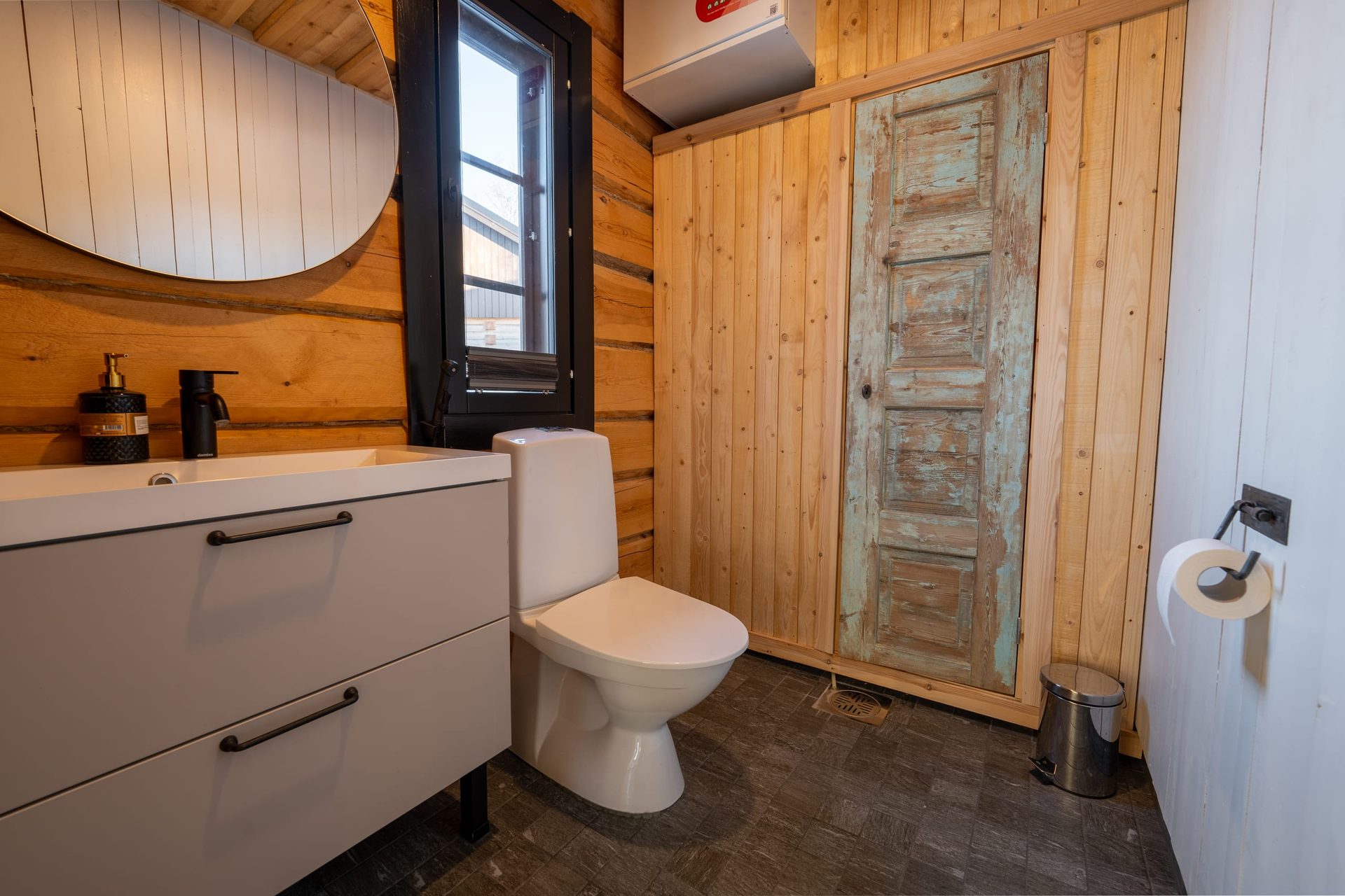Usva toilet with a sink and an old wooden door