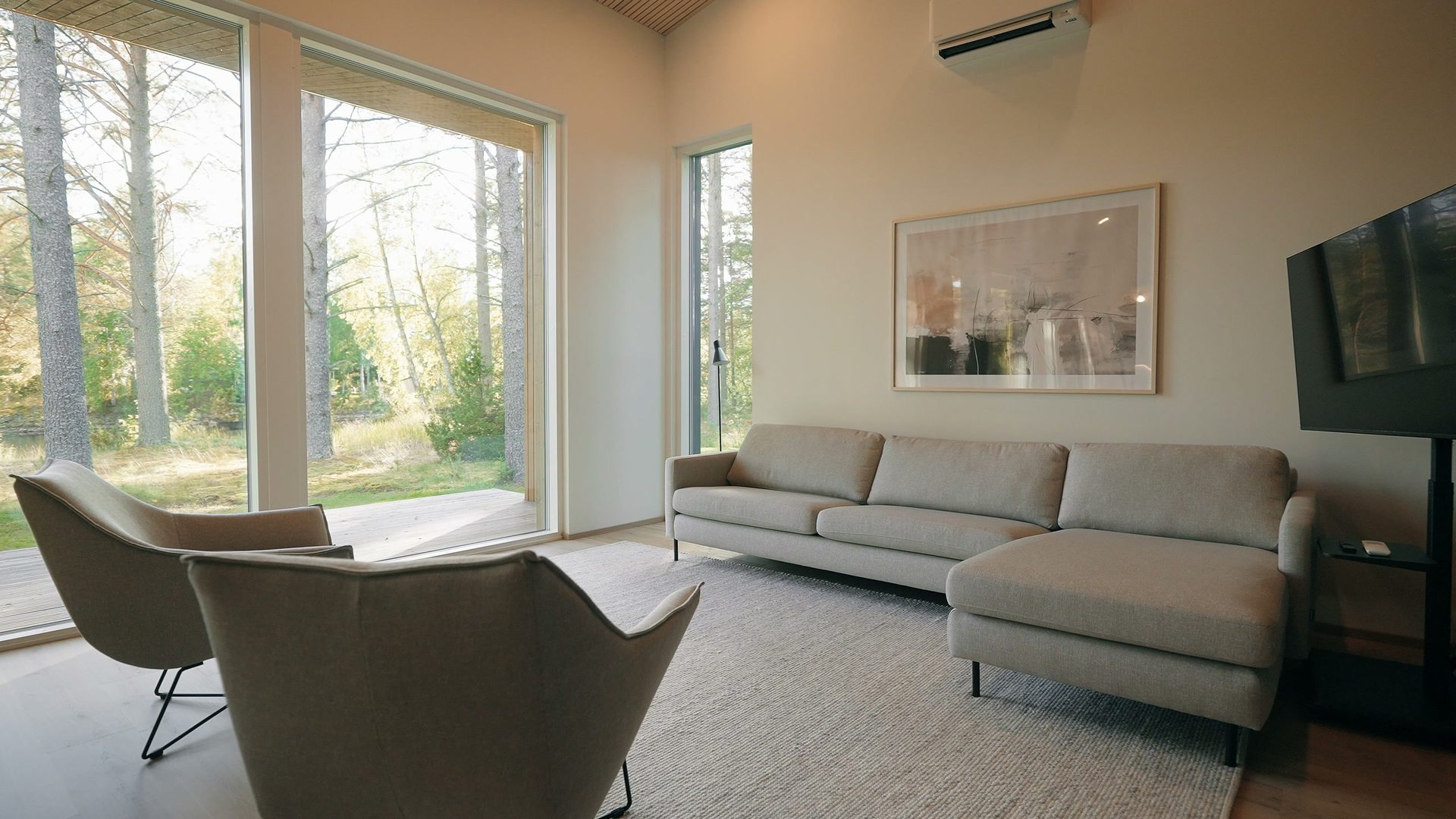 Living room with a sofa and armchairs by large windows