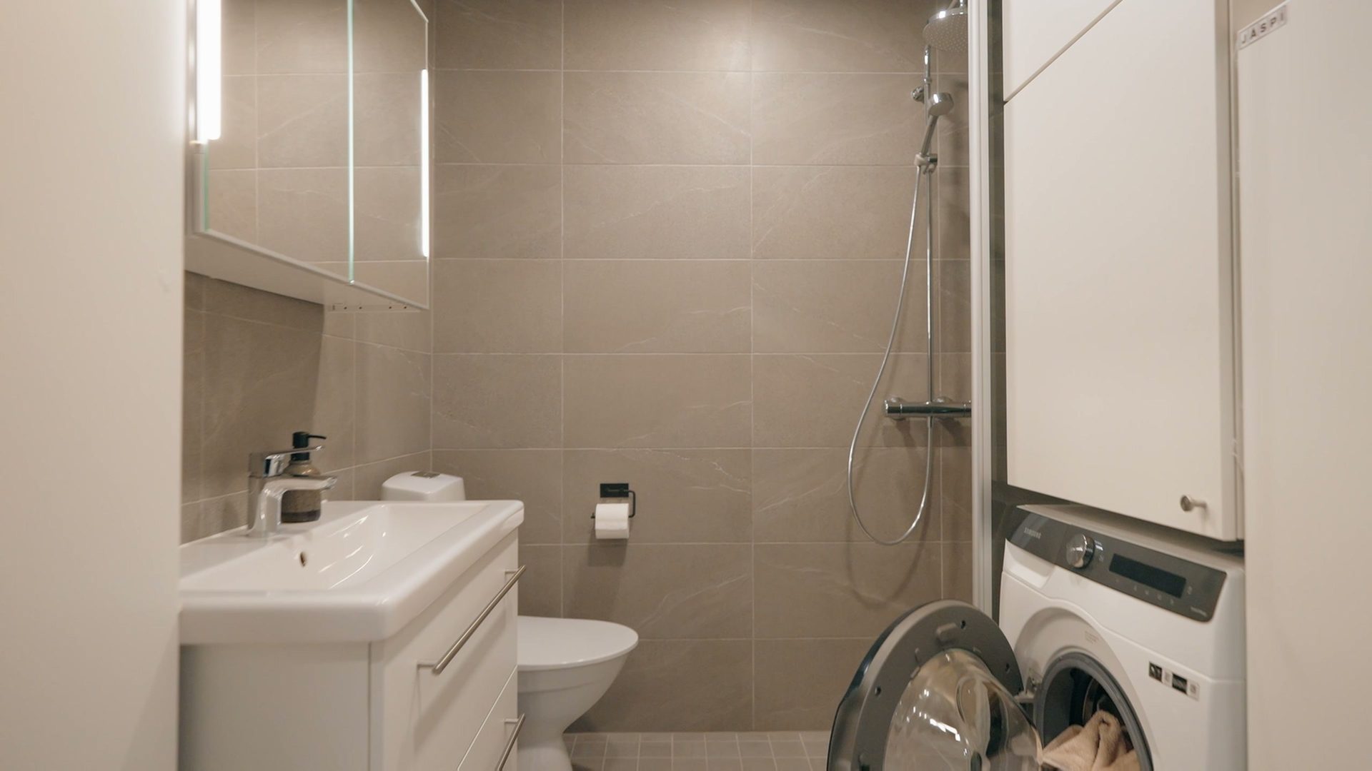 Bathroom with a shower, toilet and washing machine