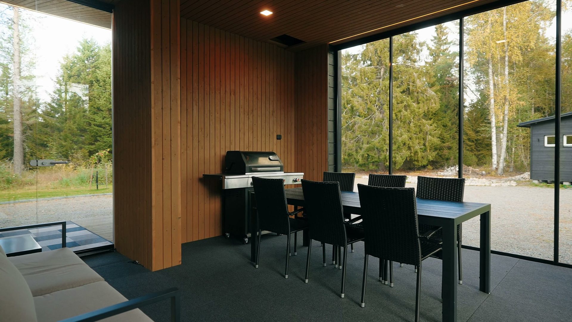 Glazed terrace with a dining table and grill