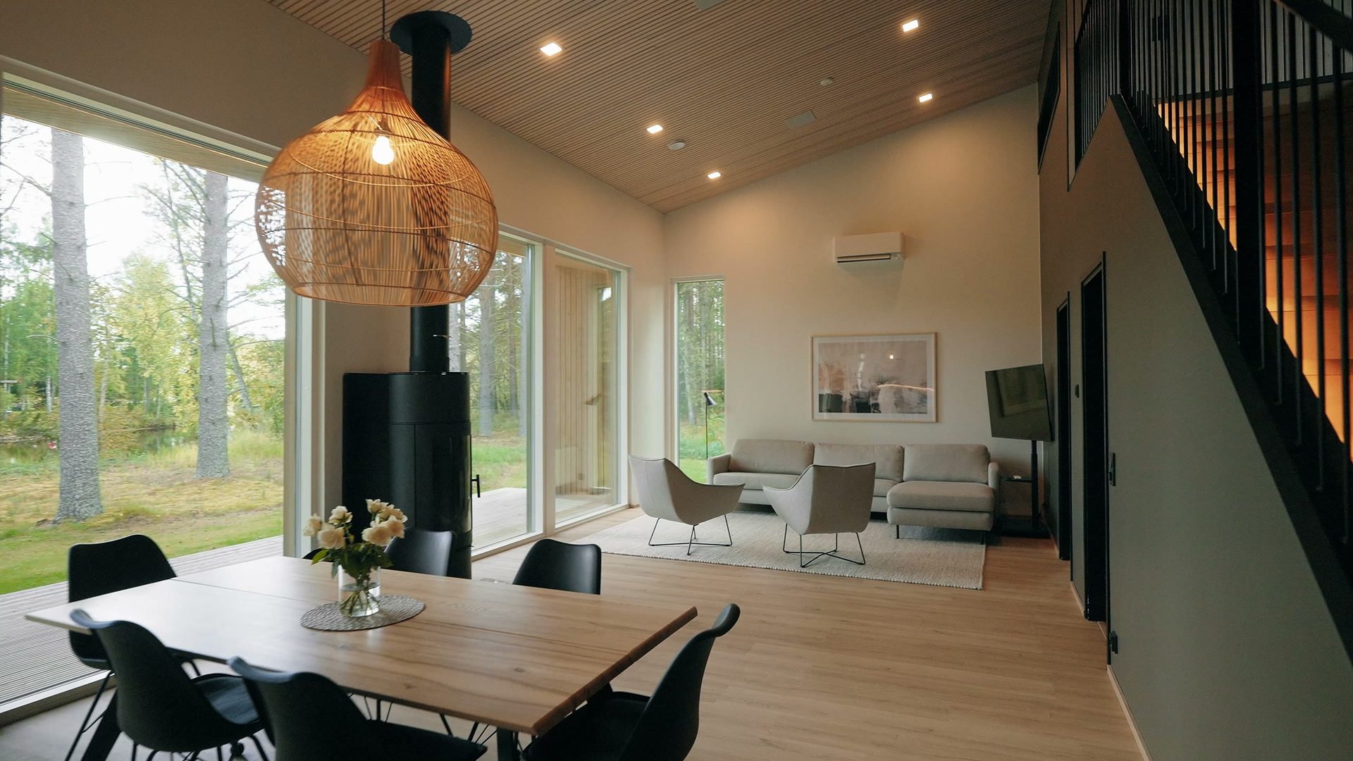 Dining table and living room in a tall, bright space