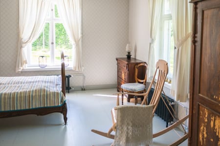 Bright Pauhu bedroom with a bed and rocking chair