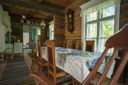 Pauhu dining table and a wall clock on the log wall