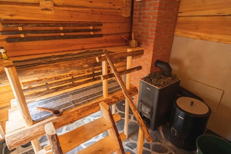 Pauhu sauna with log benches and a wood-burning stove