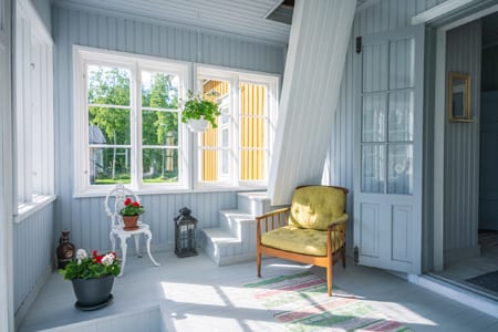 Pauhu's bright glazed porch with a yellow armchair