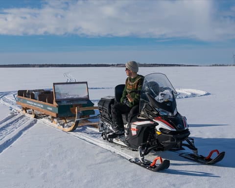 Snowmobile and sled on the ice on a sunny day