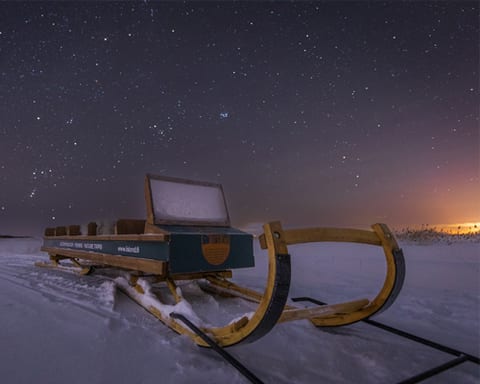 Wooden sled on the snow under a starry sky