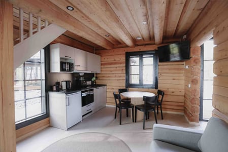 Kitchenette, round dining table and sofa in a log room