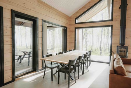 Aava dining table and large windows facing birch trees
